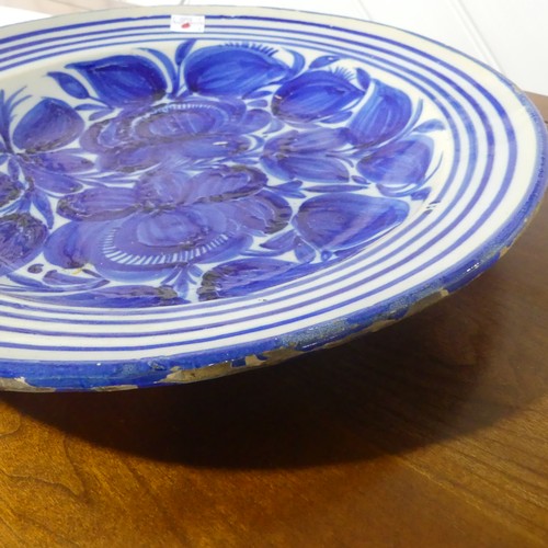 67 - A 19thC North European earthenware Charger, with blue and white decoration, chipped glaze around rim... 