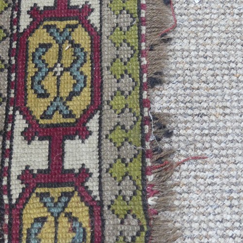 490 - Tribal rugs; a Turkish Rug, hand-knotted with ochre geometric designs on a plum ground, worn, 115cm ... 