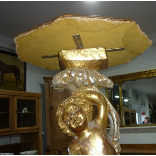 298 - A wooden carved gilt painted side table,  standing cherub to base holding octagonal table 77cm high,... 