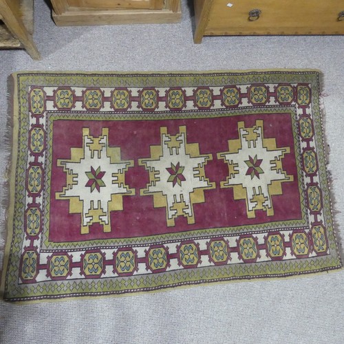 247 - Tribal rugs; a Turkish Rug, hand-knotted with ochre geometric designs on a plum ground, worn, 115cm ... 