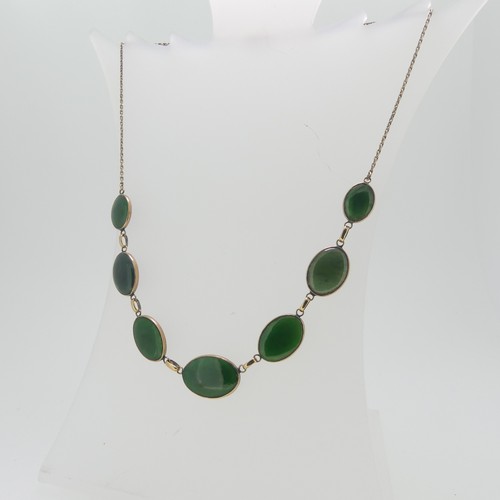 65 - An Oriental 9ct gold and jade Necklace, formed of seven graduated oval jades on an integral trace ch... 