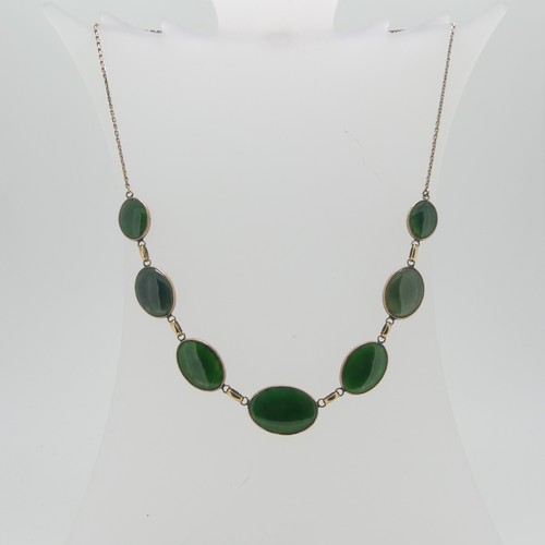 65 - An Oriental 9ct gold and jade Necklace, formed of seven graduated oval jades on an integral trace ch... 