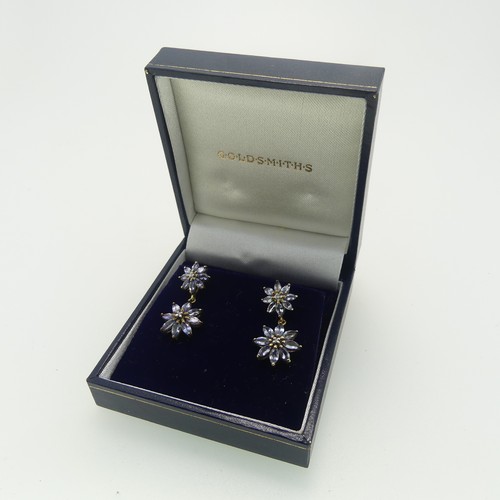 111 - A pair of tanzanite flowerhead Earrings, formed of two clusters, each with diamond point centres, al... 