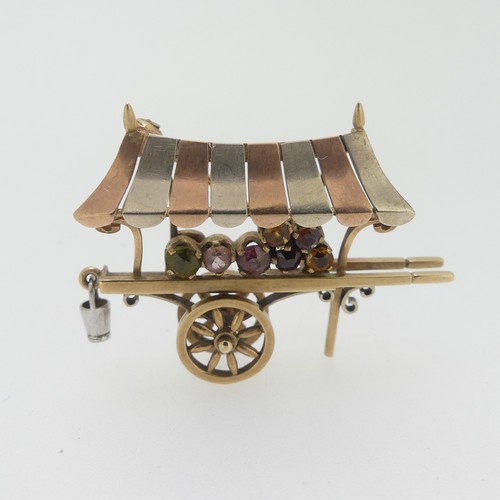 113 - A charming 9ct tri-colour gold Brooch, in the form of a hand cart, with rotating wheels, set with ha... 