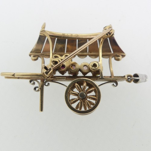 113 - A charming 9ct tri-colour gold Brooch, in the form of a hand cart, with rotating wheels, set with ha... 