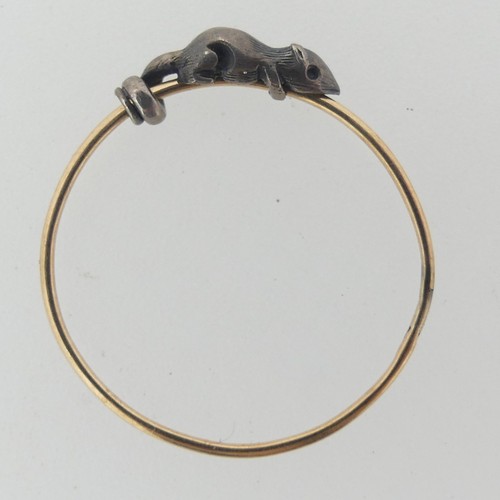 A novelty late Victorian 'Mouse' Ring, in the manner of Thornhill & Co., the narrow high carat gold band, with an applied silver mouse running freely around, Size L½.
