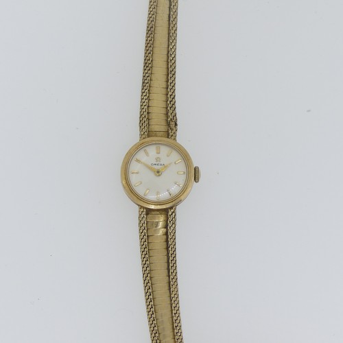 194 - An Omega 9ct gold lady's dress Wristwatch, the circular dial with gilt baton markers, on 9ct gold fl... 