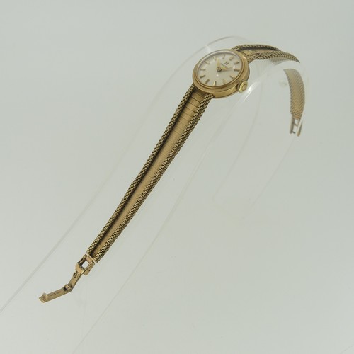 194 - An Omega 9ct gold lady's dress Wristwatch, the circular dial with gilt baton markers, on 9ct gold fl... 