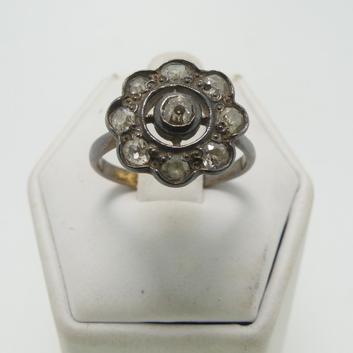 32 - A diamond flowerhead cluster Ring, the central old cut stone approx. 0.13ct, collet set with a sorro... 