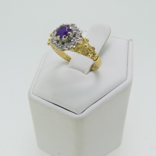 41 - An amethyst and diamond cluster Ring, the circular facetted amethyst within a surround of diamond po... 