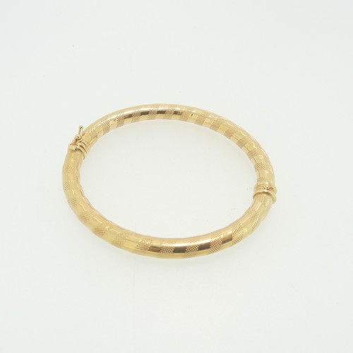 103 - An 18ct yellow gold hinged hollow Bangle, by Uno-a-Erre, with alternate bands of textured and polish... 