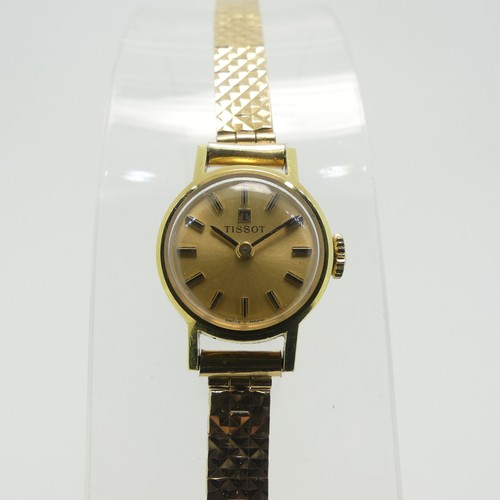 204 - A lady's Tissot Wristwatch, with champagne dial and baton markers, in a gold plated case with steel ... 