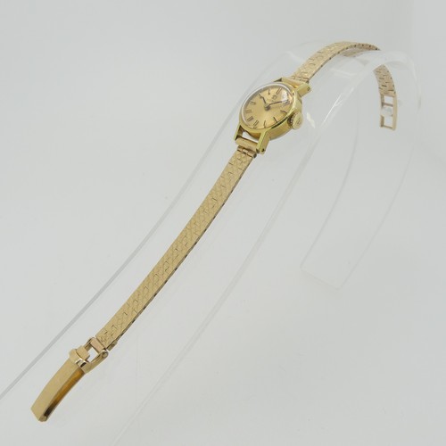 204 - A lady's Tissot Wristwatch, with champagne dial and baton markers, in a gold plated case with steel ... 