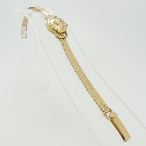 204 - A lady's Tissot Wristwatch, with champagne dial and baton markers, in a gold plated case with steel ... 