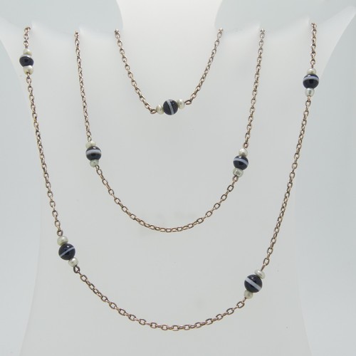 86 - A long 9ct gold chain Necklace, the oval links set with twelve groups of banded agate with seed pear... 