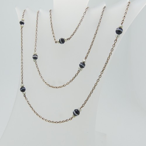 86 - A long 9ct gold chain Necklace, the oval links set with twelve groups of banded agate with seed pear... 