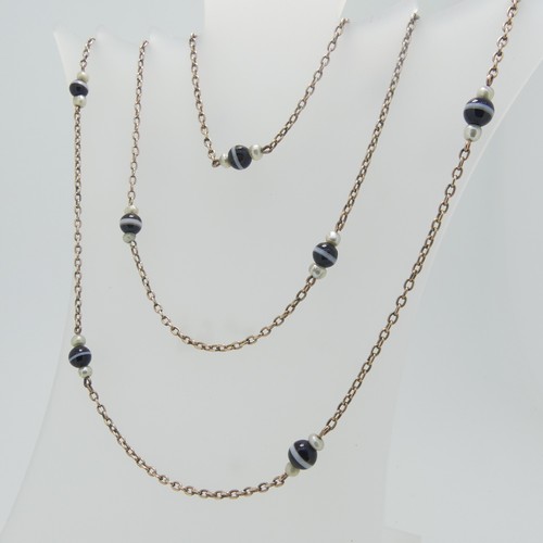 86 - A long 9ct gold chain Necklace, the oval links set with twelve groups of banded agate with seed pear... 