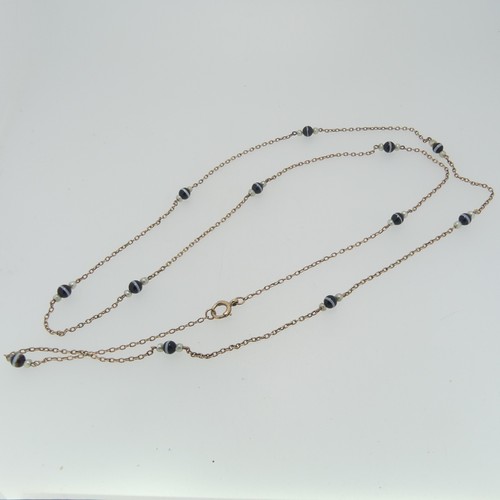 86 - A long 9ct gold chain Necklace, the oval links set with twelve groups of banded agate with seed pear... 