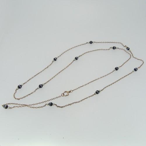 86 - A long 9ct gold chain Necklace, the oval links set with twelve groups of banded agate with seed pear... 