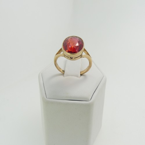 61 - A 9ct yellow gold Ring, set with an oval facetted red stone, possibly ruby, 11.8mm x 9.3mm, millegra... 