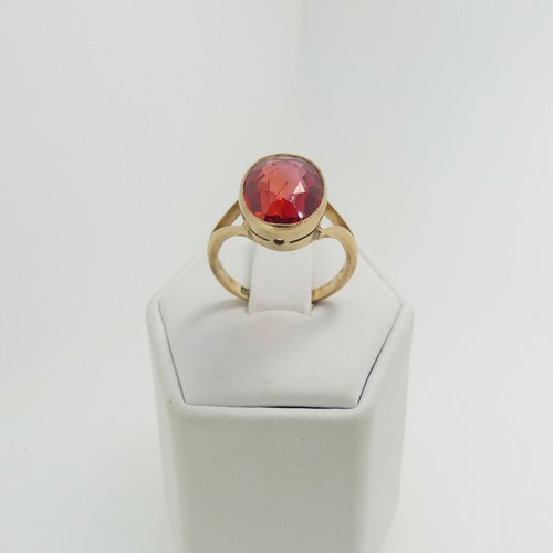 61 - A 9ct yellow gold Ring, set with an oval facetted red stone, possibly ruby, 11.8mm x 9.3mm, millegra... 