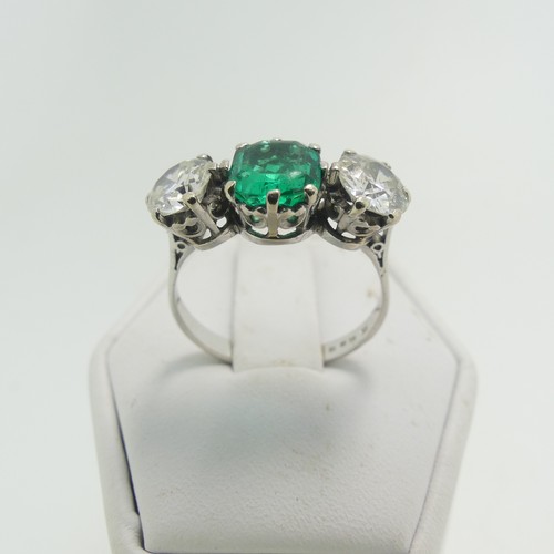 45 - An emerald and diamond three stone Ring, the central octagonal step cut emerald, approx 1.2ct, with ... 