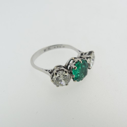 45 - An emerald and diamond three stone Ring, the central octagonal step cut emerald, approx 1.2ct, with ... 