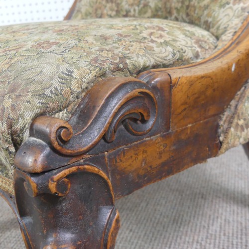 254 - A Victorian carved upholstered nursing chair, with floral carved press rail upon cabriole legs and s... 