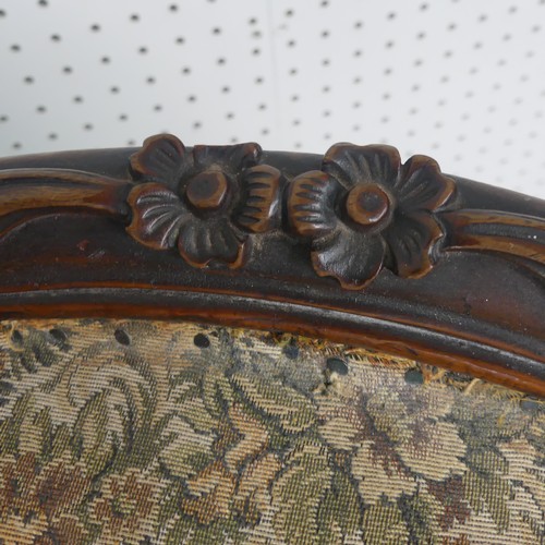 254 - A Victorian carved upholstered nursing chair, with floral carved press rail upon cabriole legs and s... 