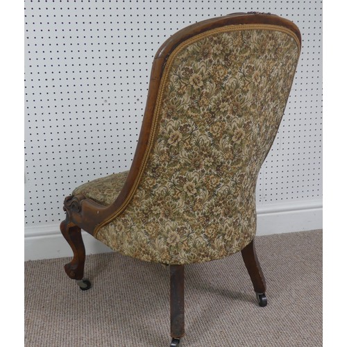 254 - A Victorian carved upholstered nursing chair, with floral carved press rail upon cabriole legs and s... 