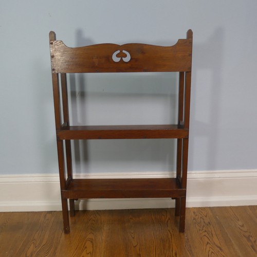 268 - A walnut free standing three shelved Arts and Crafts inspired Bookcase, with open back and pierced d... 