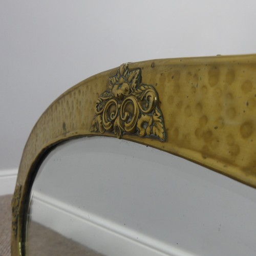 270 - An Arts & Crafts oval brass mirror with decorative overlay to four of its edges, has it's origin... 