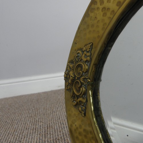 270 - An Arts & Crafts oval brass mirror with decorative overlay to four of its edges, has it's origin... 