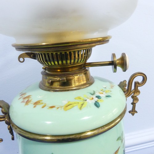 281 - An Edwardian glass and gilt-metal oil lamp, with  moulded shade above a green opaque oviform lamp ba... 