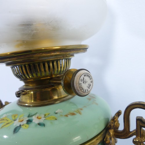 281 - An Edwardian glass and gilt-metal oil lamp, with  moulded shade above a green opaque oviform lamp ba... 