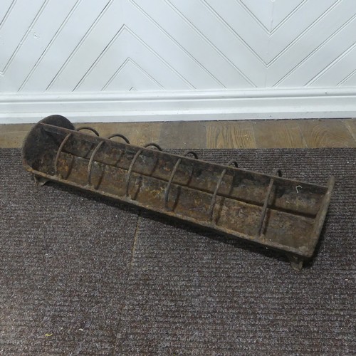 407 - An antique cast iron pig feeder, W 95 cm x H 18 cm x D 25 cm.