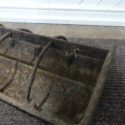 407 - An antique cast iron pig feeder, W 95 cm x H 18 cm x D 25 cm.