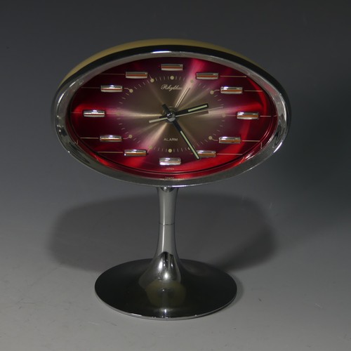 233 - A retro Rhythm (Japan) Alarm Clock, circa 1960s, with oval pink tinted face and chromed edge of case... 