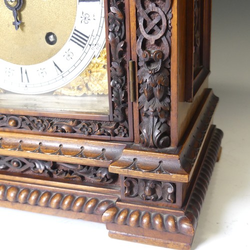 228 - A attractive late 19th century continental carved walnut Mantel Clock, with arched brass dial, silve... 