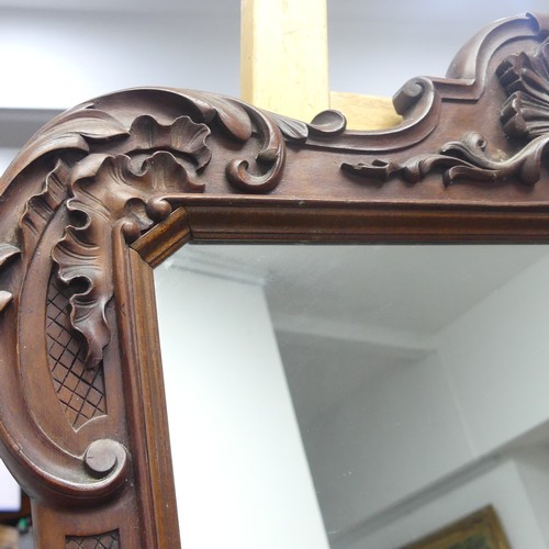 235 - A decorative wall mirror with carved hardwood frame (formally a fire screen), W 64cm x H 96cm.... 