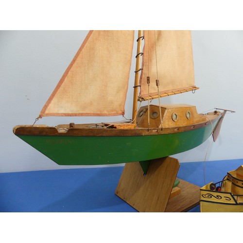 435 - A wooden model sailing yacht, with mask, sails, anchor, wooden rudder cabin with windows, painted gr... 