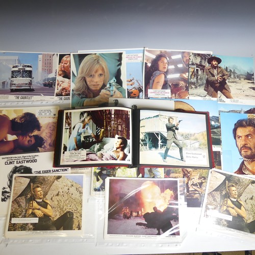 76 - A quantity of Clint Eastwood movie Lobby Cards, including ; an album with taped down sets consisting... 