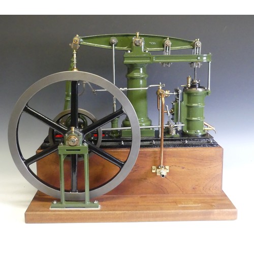 A superb model of a Stuart Turner Major Beam engine, the engine based on the design by Mr George Gentry with modifications by Mr H A Taylor in 1968, with central turned column supporting beam with Watts parallel motion, vertical driven water pump, single vertical cylinder 1¾ inch bore by 3¾ inch stroke with inside steam chest, speed governor with shut off linkage to steam inlet and having 13¾ inch diameter spoked flywheel, finished in green and red and set on a wooden plinth bearing brass builders plaque ‘Stuart Major Beam Engine built by Maurice Bealey’, overall dimensions W: 24in (61cm) x H: 20in (51cm) x D: 12in (30.5cm), with Perspex dust cover.