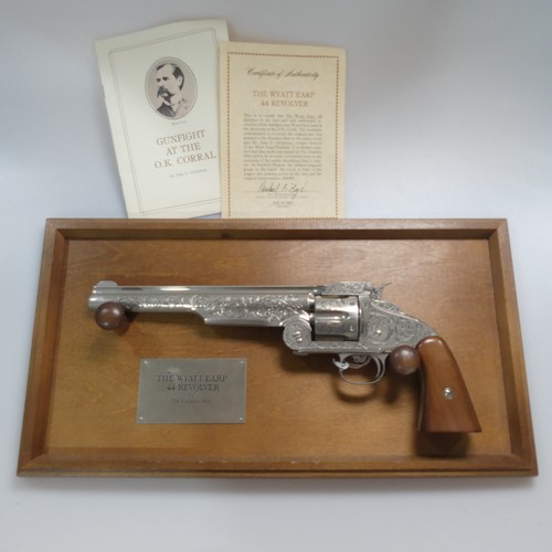 445 - A Franklin Mint replica Wyatt Earp .44 Revolver with wood grips, a wooden display hanging frame, tog... 