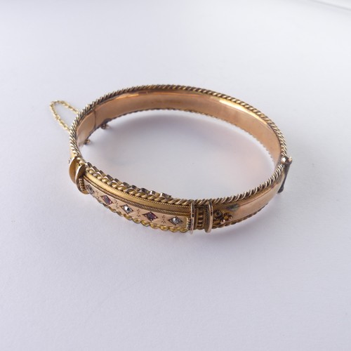 390 - A late Victorian 9ct gold hinged Bangle, the front set with five ruby and diamond points, with ropet... 