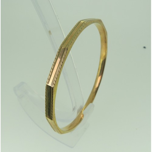 394 - A 9ct gold Bangle, dodecagon with engraved edges, 7.3cm internal diameter, 14.1g.