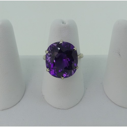 297 - An amethyst Dress Ring, the oval facetted stone 15.75x13.9mm, claw set in 9ct white gold, Size N, 4.... 