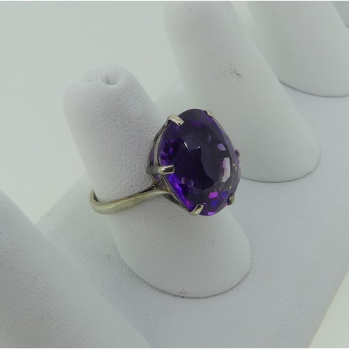 297 - An amethyst Dress Ring, the oval facetted stone 15.75x13.9mm, claw set in 9ct white gold, Size N, 4.... 