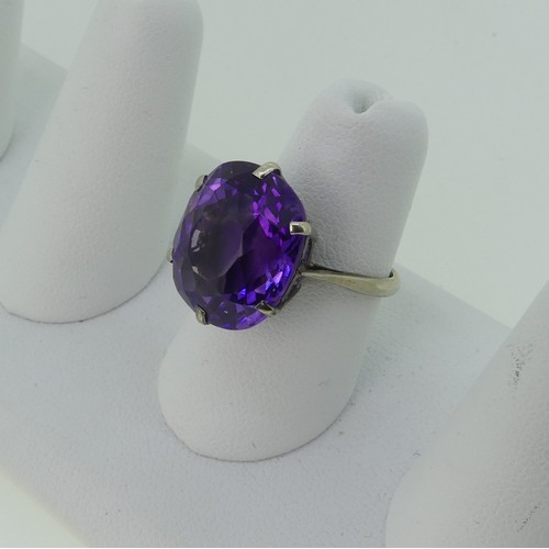 297 - An amethyst Dress Ring, the oval facetted stone 15.75x13.9mm, claw set in 9ct white gold, Size N, 4.... 