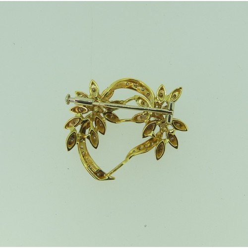 425 - An 18ct yellow gold and diamond foliate Brooch, the two principle diamonds each approx. 0.14ct, with... 